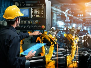 male engineer wearing a yellow hard hat inspects machinery